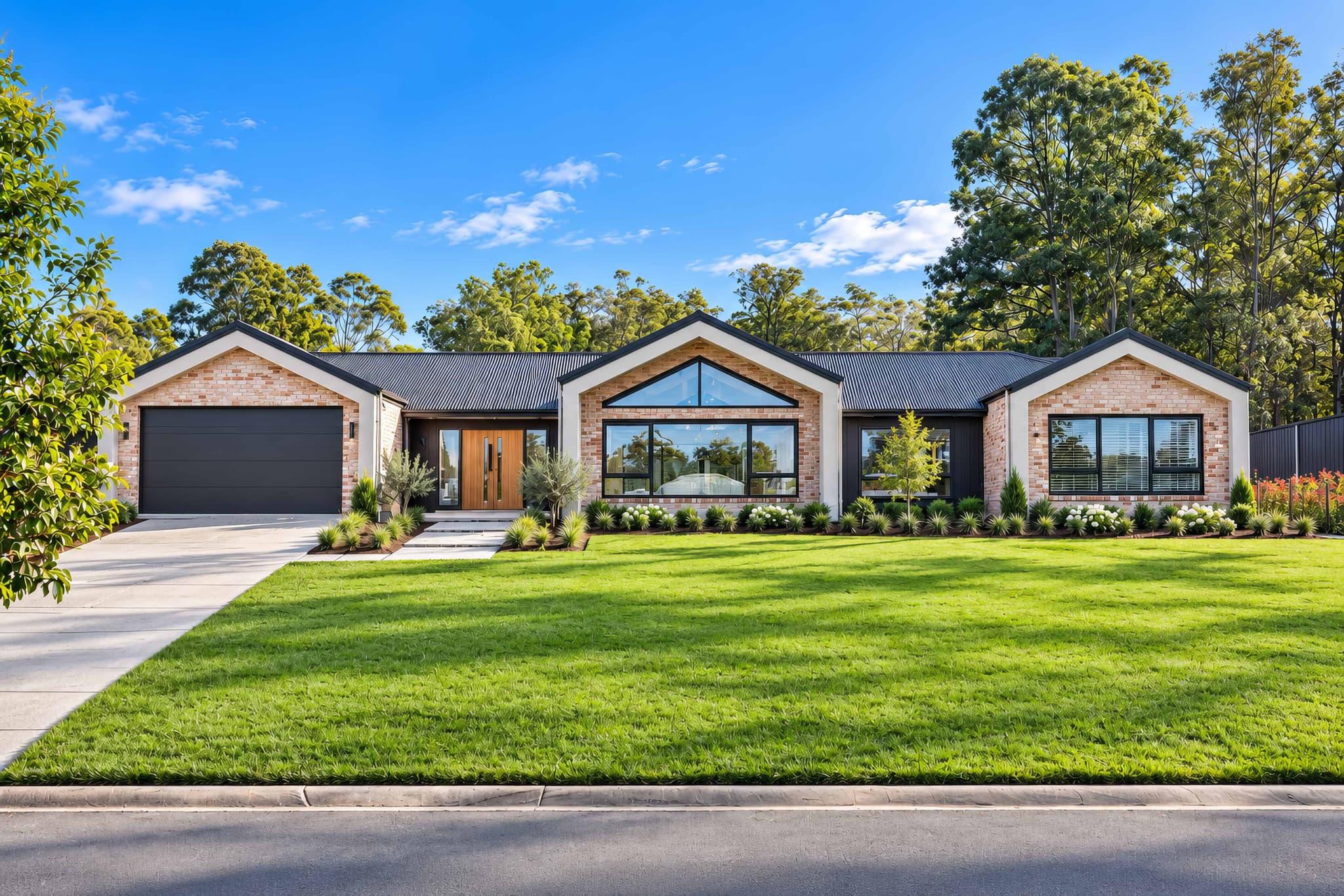 The same home with a virtual green lawn, planted gardens and a bright blue sky