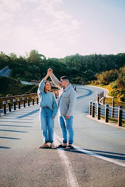 Couple dancing on a winding coastal road