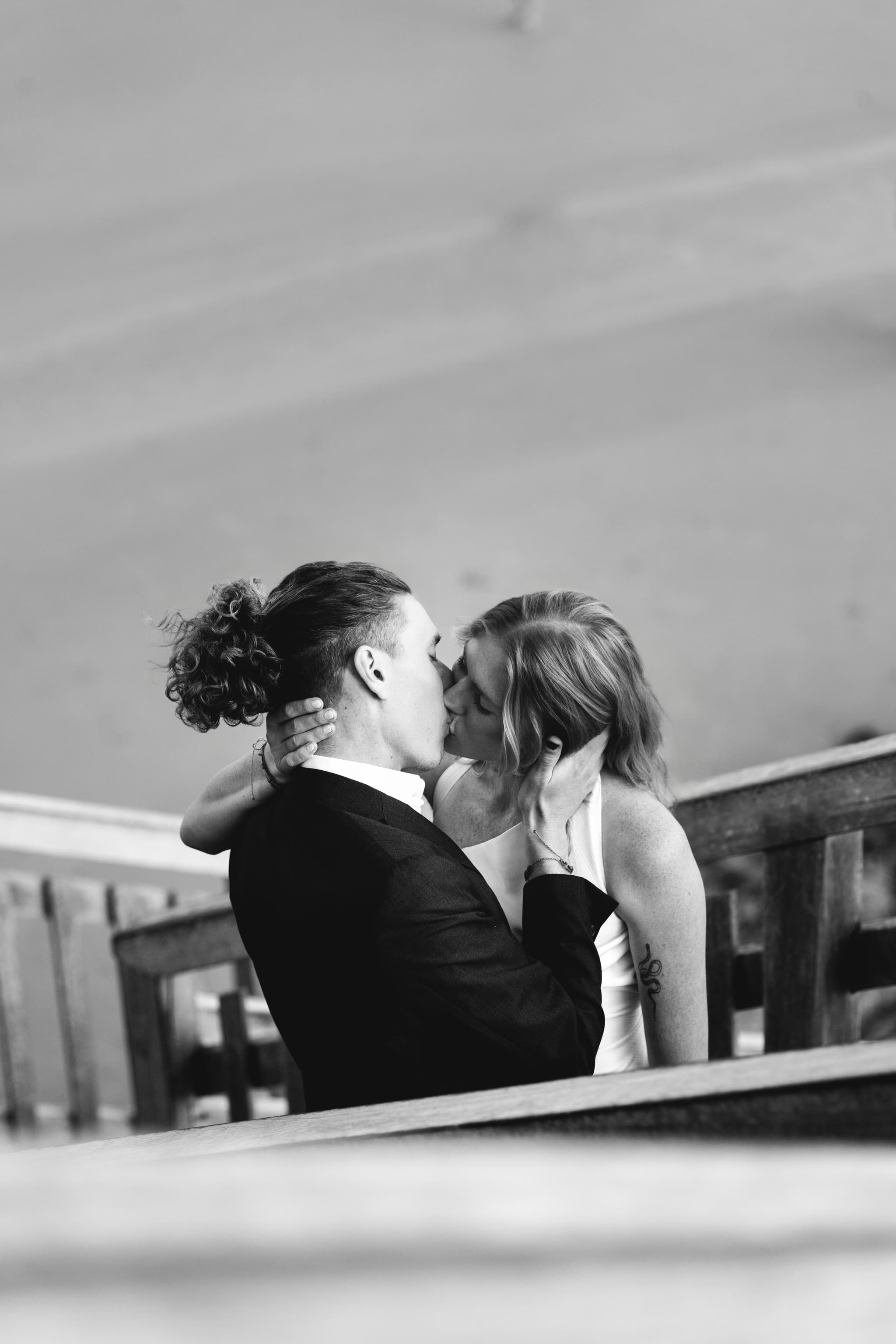 Black and white portrait of Chloe and JoJo kissing on the timber stairs