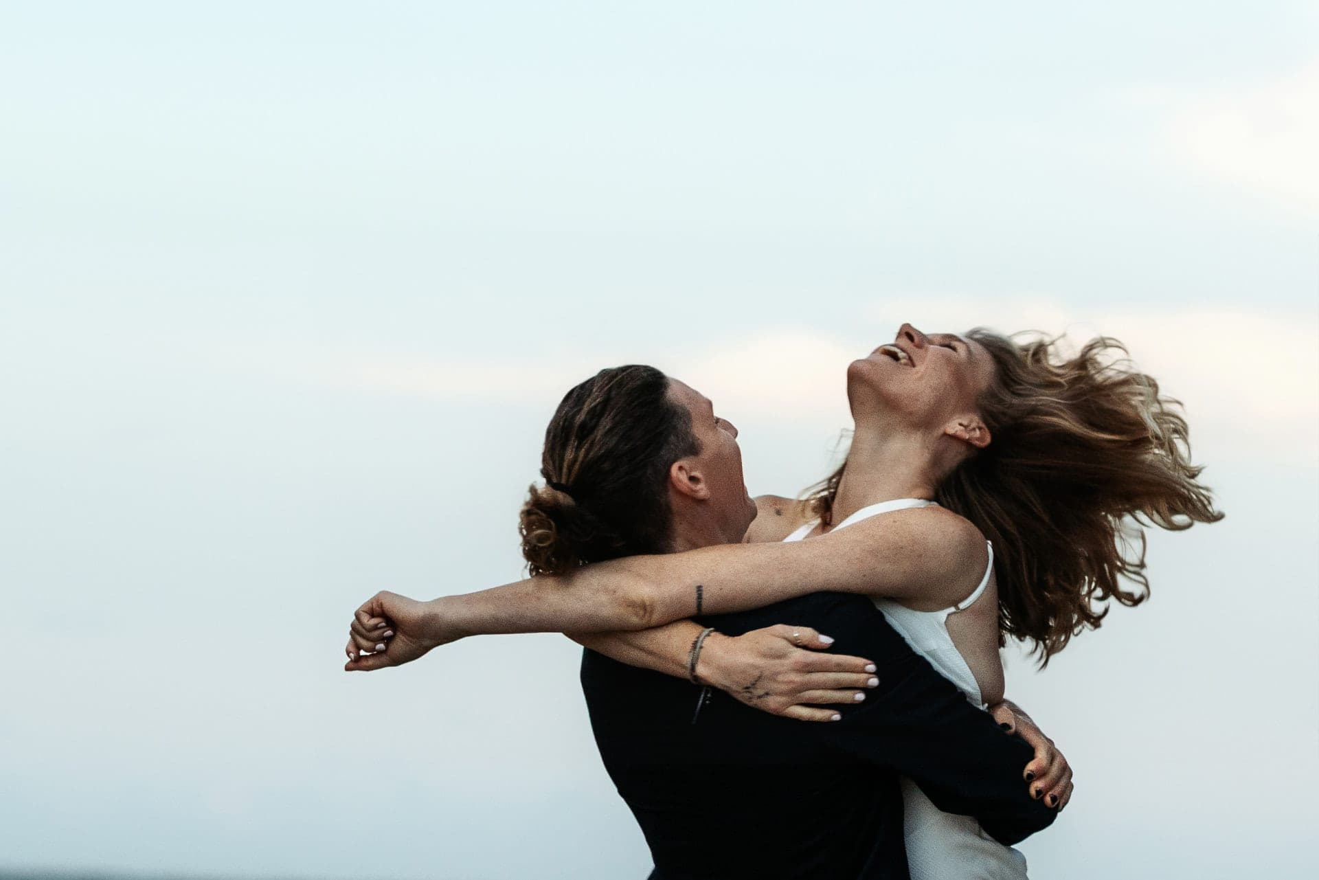 Groom lifting the bride into the sky, her hair flying