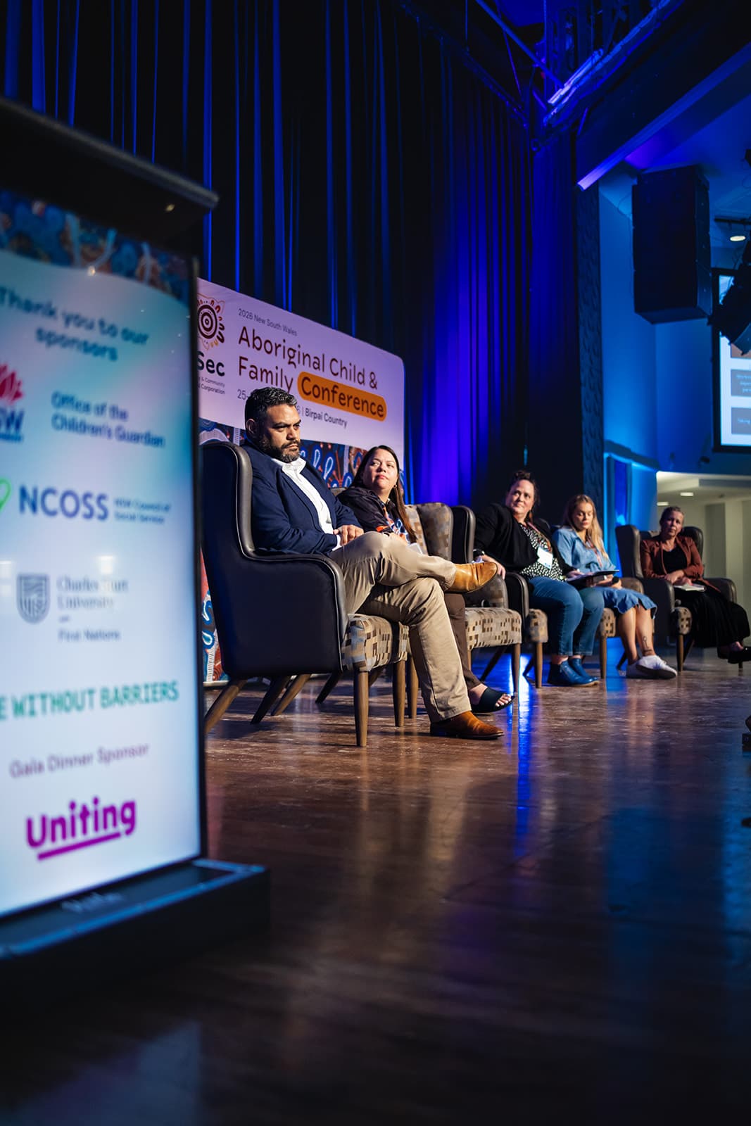 Panellists in conversation beside the sponsor banner
