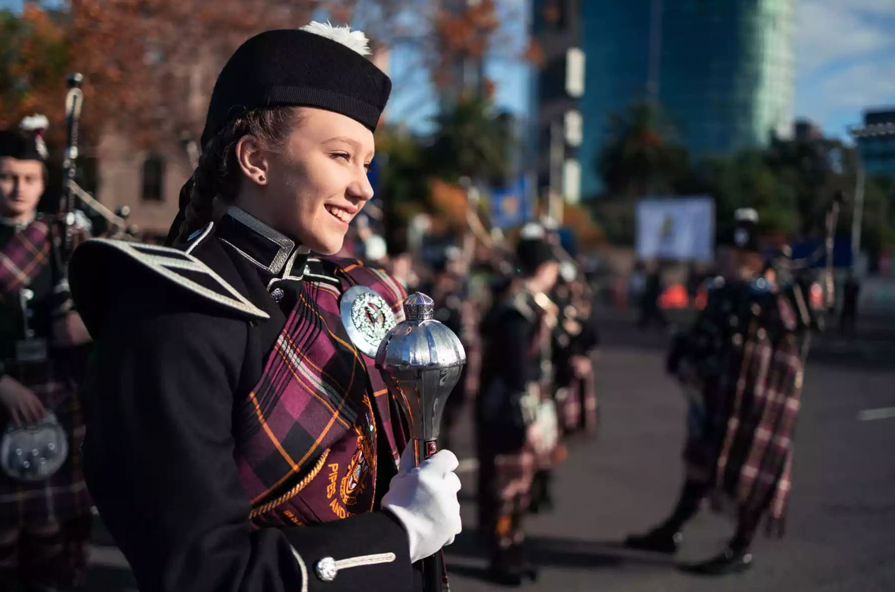 Pipe band drum major marching in a street parade