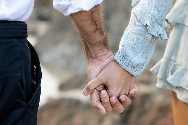 Close detail of the couple holding hands
