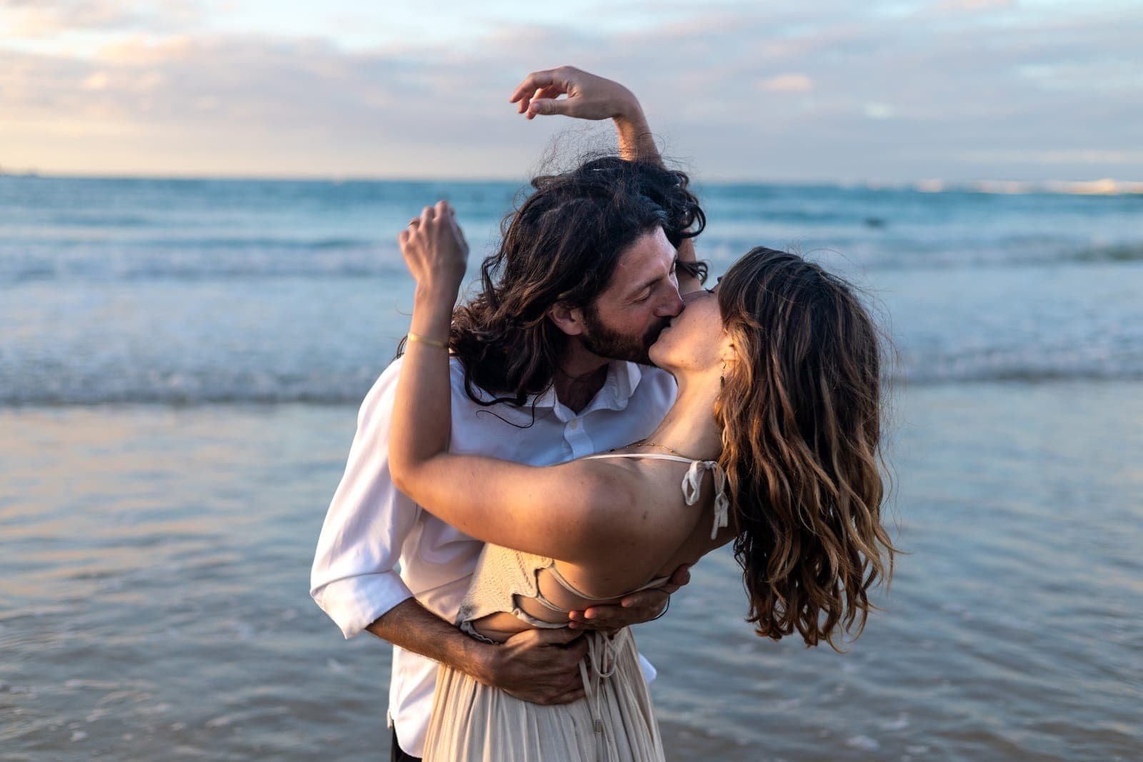 Jerome dipping Charlene into a kiss at the water's edge