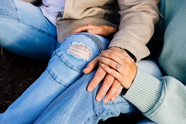 Detail of the engagement ring as Tia rests her hand on Joseph's knee