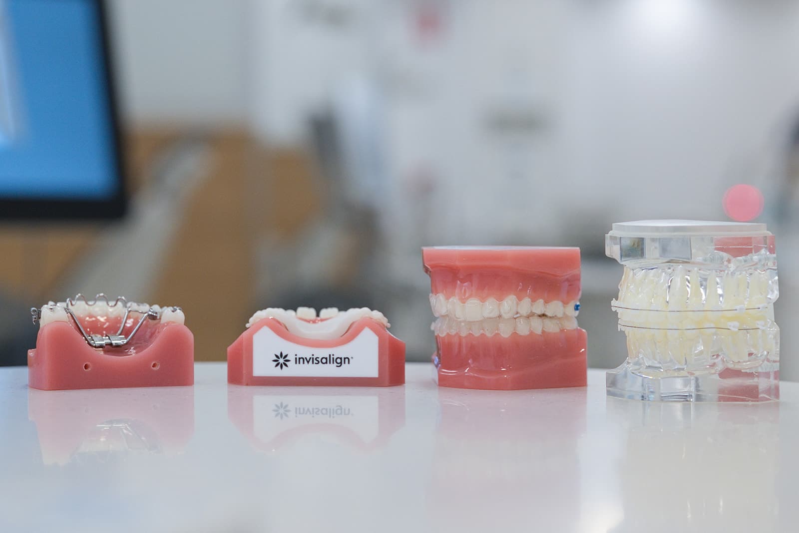 Row of orthodontic models including braces and Invisalign aligners
