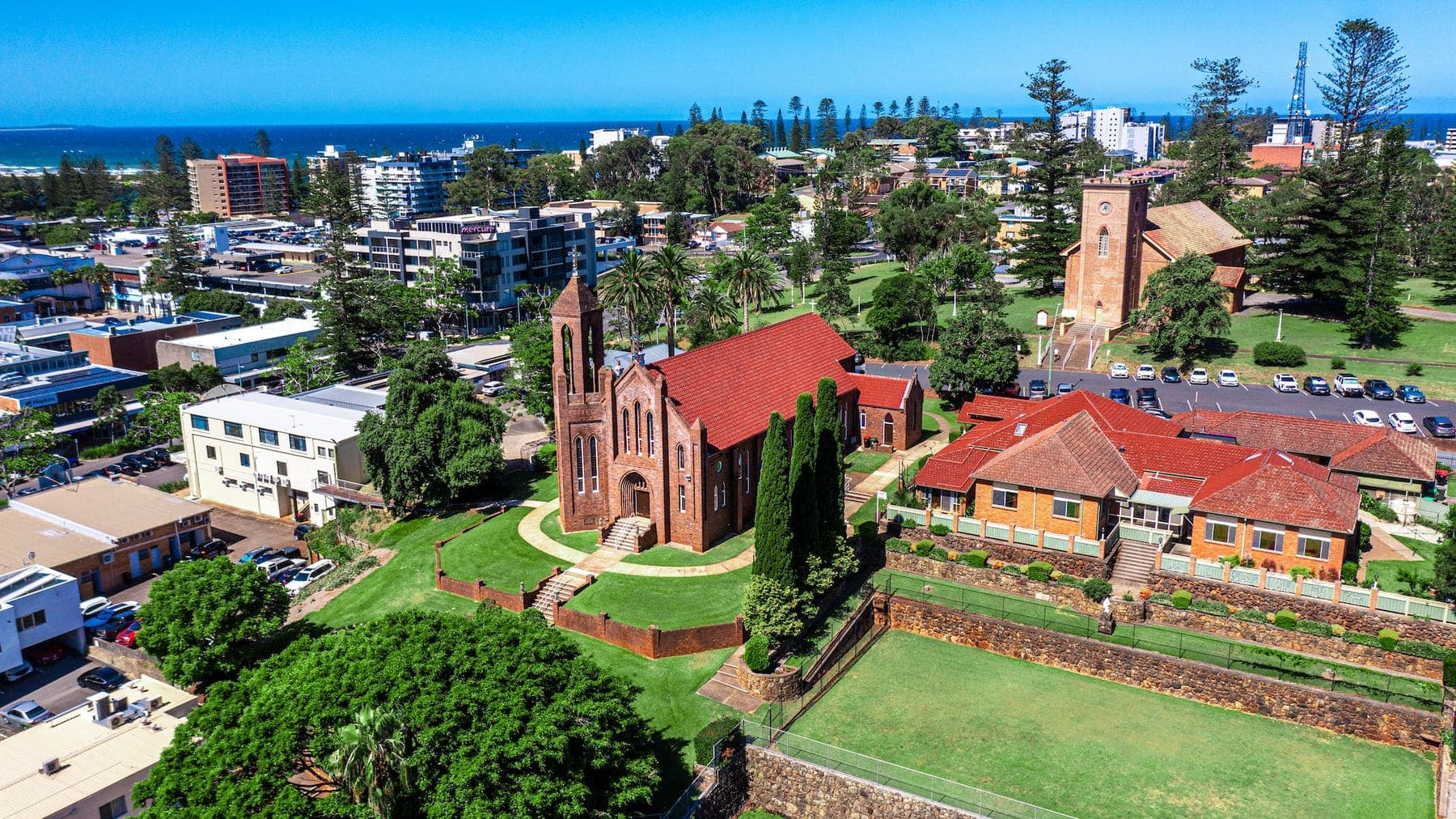 Aerial of a red-roofed church and coastal town