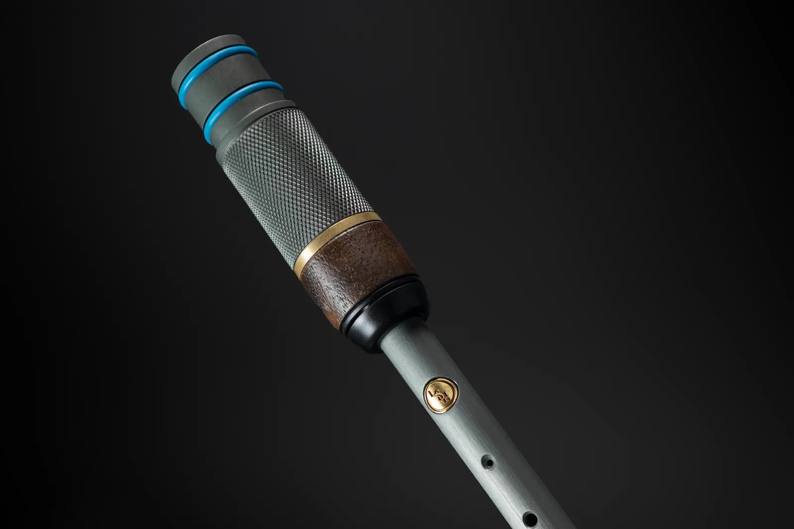Close-up of a textured instrument with brass and timber detailing
