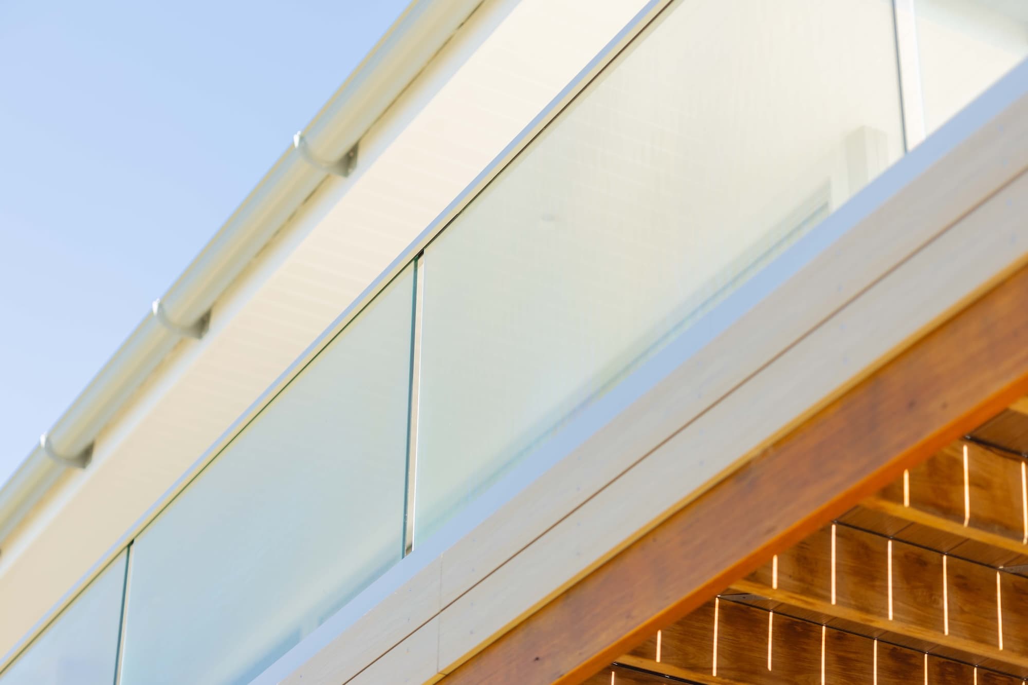 Frameless glass balustrade above a lit timber soffit