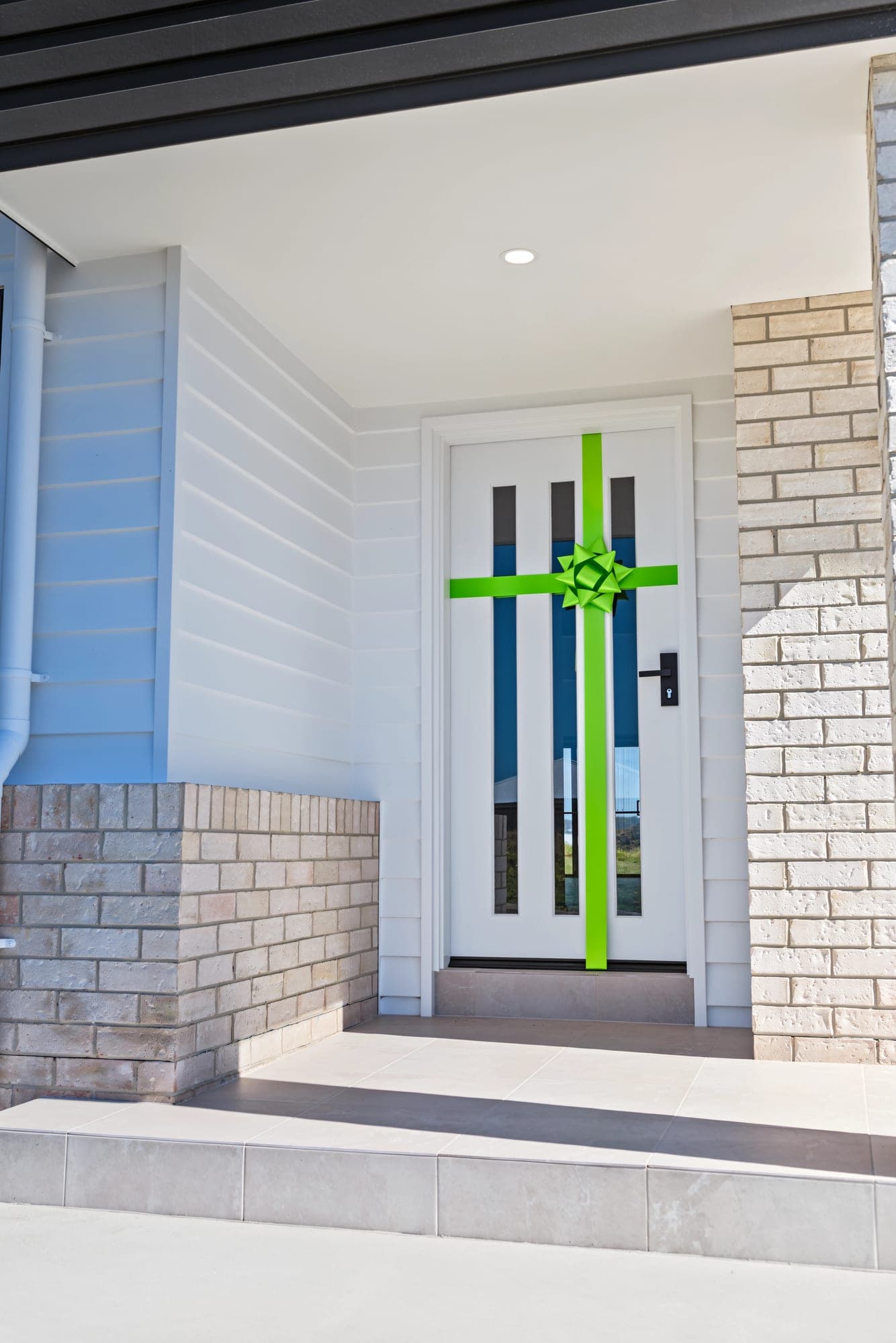 Front door wrapped in a green handover ribbon and bow